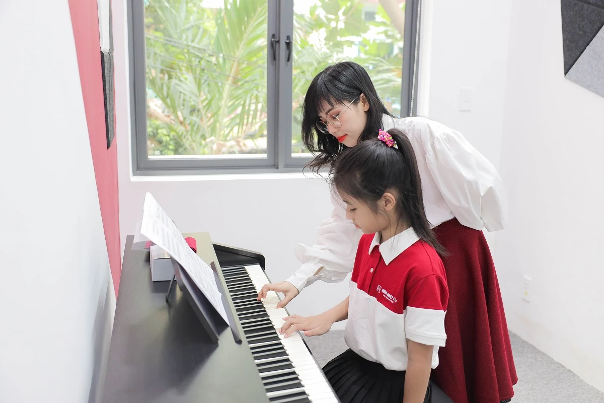giảng viên hướng dẫn bé tập piano